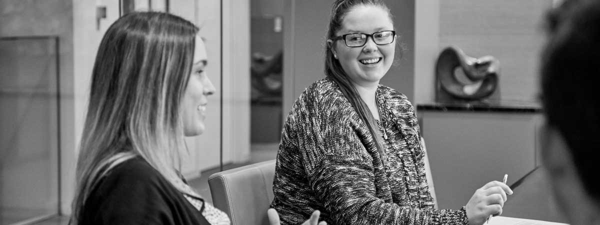 Two Reyes Holdings team members sitting down at a conference room and having a pleasant discussion.