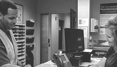 Deux membres de l'équipe de Reyes Holdings debout dans un bureau.