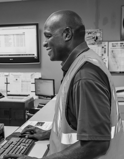 A Reyes Holdings team member working at the computer in workstation.