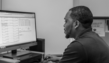 A Reyes Holdings team member working at the computer in workstation.