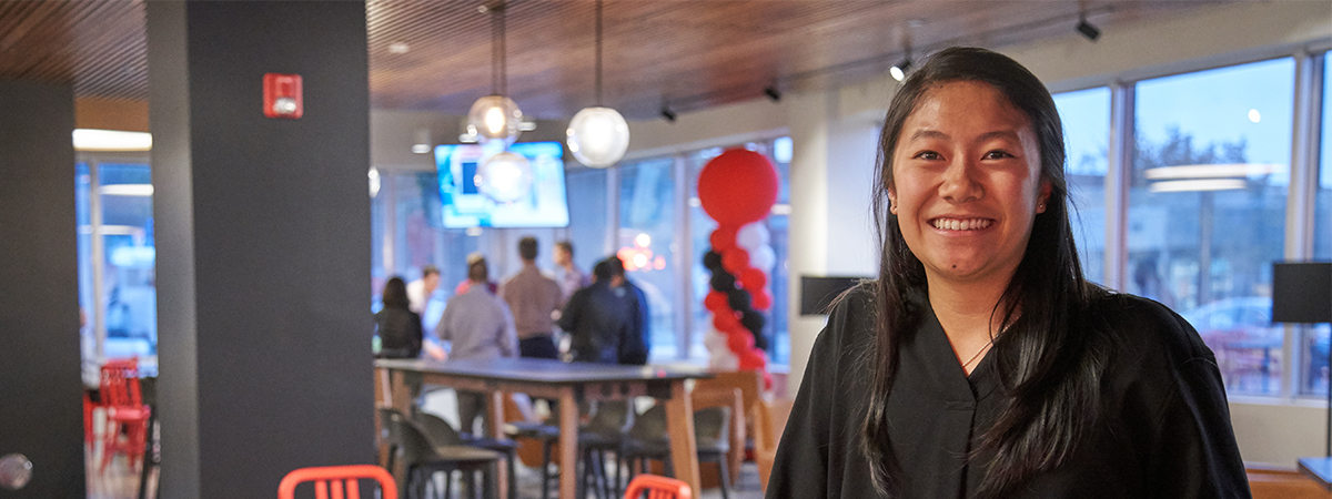 Reyes Coca-Cola Bottling employee stading in cafeteria and holding a Coca-Cola can.