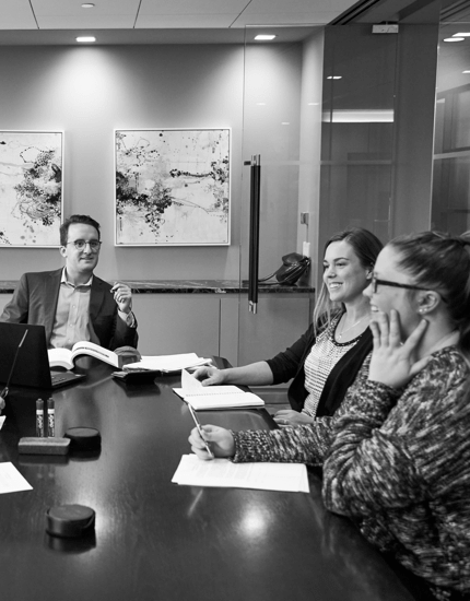 A group of Reyes Holdings team members sitting in conference room.